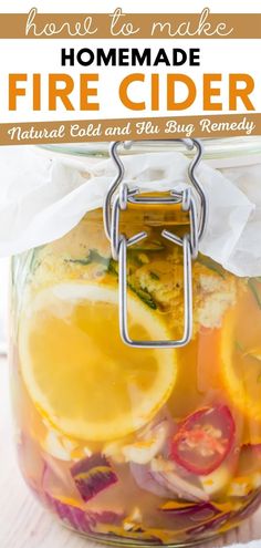 homemade fire cider recipe in a jar with lemons, onions and peppers on top