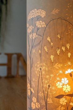 a lamp that is on top of a table next to a vase with flowers in it