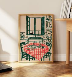 an art print is displayed on the wall next to a table and bookshelf