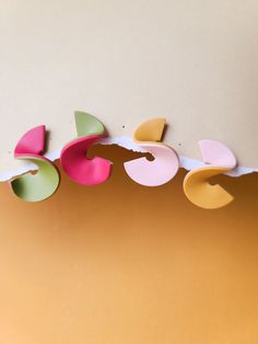 four different colored pieces of paper hanging from the ceiling