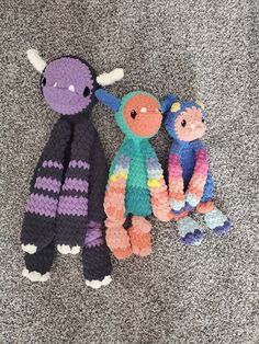 three knitted stuffed animals laying on the floor