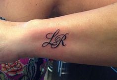 a woman's arm with a tattoo that has the initials k and l on it