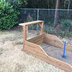 a wooden bench sitting in the middle of a yard