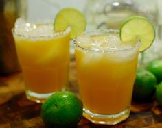 a close up of a drink on a table with a lime and an orange slice