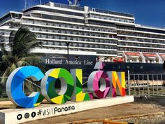 a large cruise ship is docked in the water behind a sign that says cocon