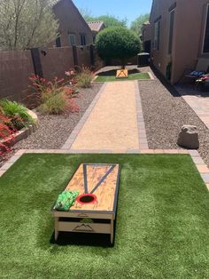 a wooden table sitting on top of a green grass covered ground next to a yard