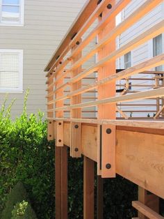 an outside view of a house with wood slats on the railings and bushes