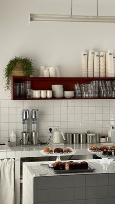 the kitchen counter is covered with dishes and cups