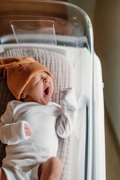 a baby in a crib is yawning