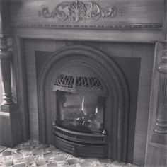 an old fireplace with a fire place in the middle and tile flooring around it