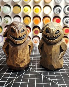 two wooden carved pumpkins sitting on top of a table