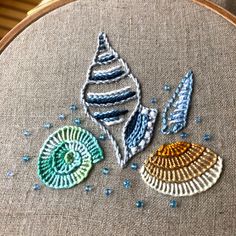 an embroidery project with three seashells on it