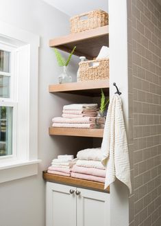 towels are stacked on shelves in the bathroom