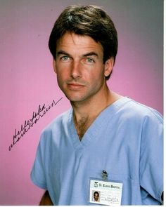 an autographed photograph of a man in scrubs with a name tag on his shirt