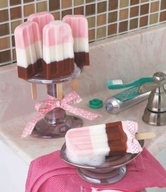 three popsicles are sitting on a plate in the bathroom