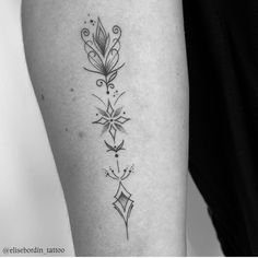 a black and white photo of a woman's arm with an intricate tattoo design on it