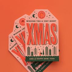 three christmas cards with the words xmas printed on them, sitting next to each other