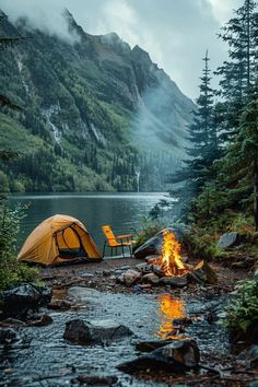 a tent is set up on the shore of a mountain lake next to a campfire