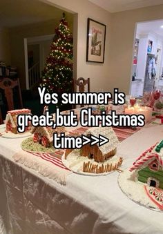 a table topped with lots of cakes covered in icing next to a christmas tree