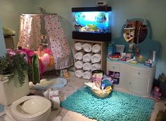 the bathroom is decorated in pastel colors and has a fish tank on the wall