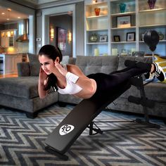 a woman laying on top of a bench in a living room