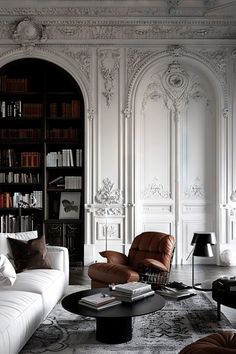 Interior Design With White Walls, Haussmann Interior, Parisian Interior Design, Parisian Luxury, Arched Doorways, Brown Leather Armchair, Black Bookcase, Parisian Interior, Classical Interior