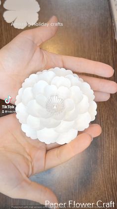 a person holding a paper flower in their hand