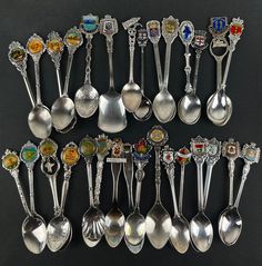 an assortment of spoons with different designs and colors are shown in this image on a black background