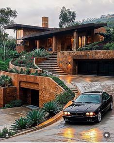 a black car parked in front of a house with steps leading up to the roof