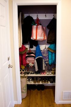 an open closet with shoes and bags on the shelves