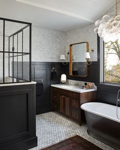 a bathroom with a tub, sink and large mirror in the corner next to a window