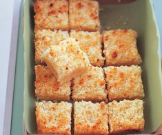 several squares of food sitting in a green tray