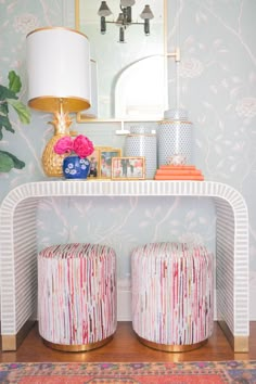 two stools in front of a mirror on top of a shelf next to a lamp