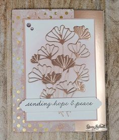 a card with some flowers on it sitting on a piece of wood that says sending hope and peace