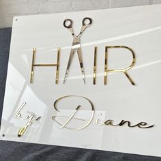 scissors are sitting on top of a sign that says hair by jane