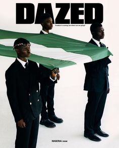 two men in suits are holding a green and white flag with the word dazed on it