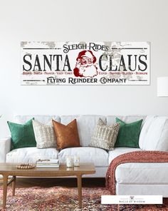 a living room filled with furniture and a santa clause sign on the wall above it