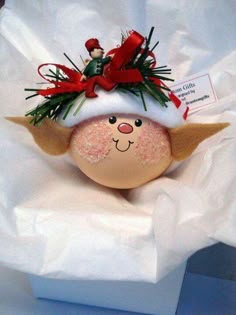 an egg with a santa hat on it's head sitting in a white box