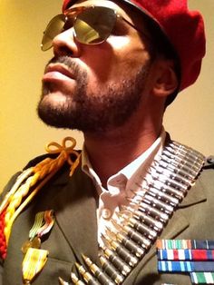 a close up of a person wearing sunglasses and a hat with metal decorations on it