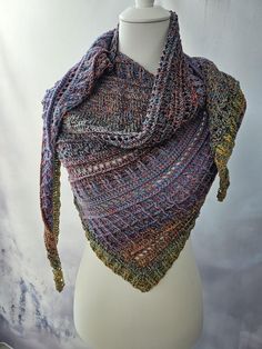 a mannequin wearing a multicolored knitted shawl