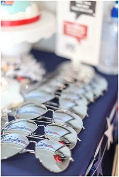 many sunglasses are lined up on a table