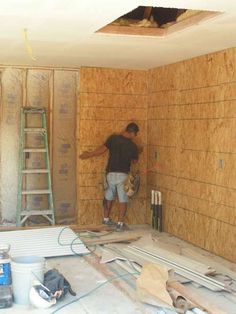 a man standing in the corner of a room under construction