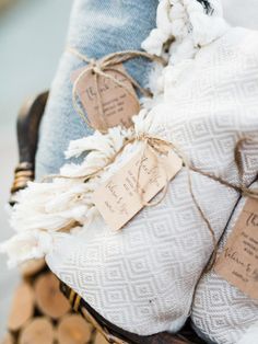 two towels wrapped in twine and tied with string on top of stacked wood logs