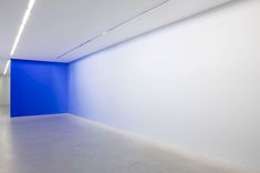 an empty room with white walls and blue paint on the wall is seen in this image