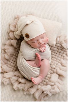 a baby wrapped in a blanket and wearing a hat