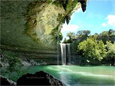 an image of a waterfall in the middle of a river with trees and rocks around it