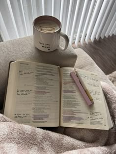 an open book and cup of coffee on a chair