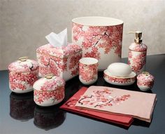 a table topped with pink and white items on top of a black countertop next to a wall