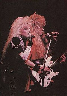 two women on stage with guitars and microphones