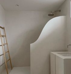 a white bathroom with a ladder in the corner and a sink on the other side